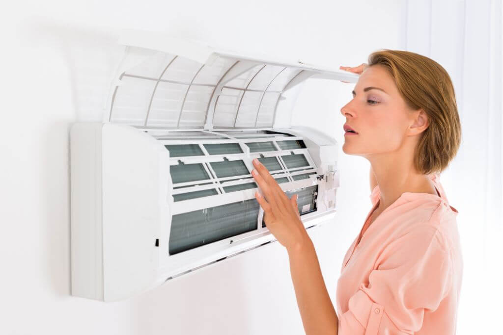 An air conditioner contractor is checking the cooling of an AC